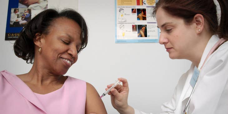 Company nurse administering vaccine to an employee.