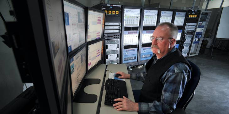 Computer Operator sitting at his workstation and monitoring the company's network performance