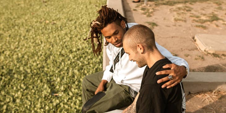 Correctional Treatment Specialist putting his arms around a smiling man along the pavement