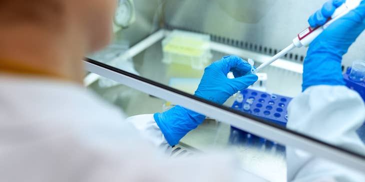 A Female Criminalist applying chemicals to an evidence to analyze and file a report for the test results.