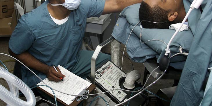 Certified Registered Nurse Anesthetists monitor the patient during a medical procedure.