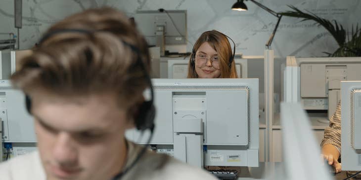 focused photography of a Customer Service Representative on duty wearing glasses and sitting in her workstation