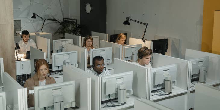 a team of Customer Service Specialists taken during work hours while they are sitting on their respective workstations