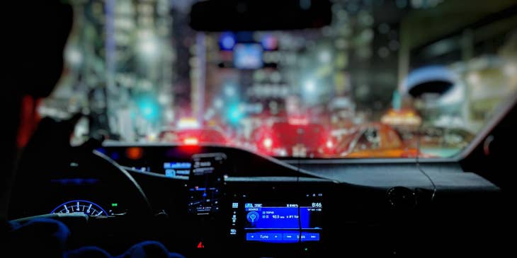 A Driver driving around the city about to pick up a client from a hotel.