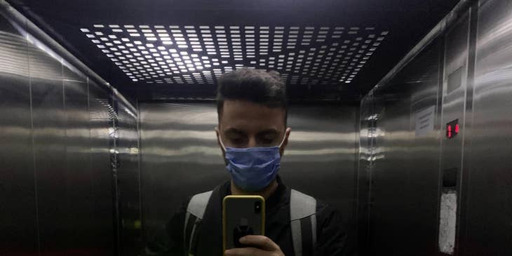 man with a mask on in an elevator