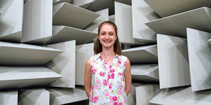 female Engineer smiling and standing behind her own architectural design