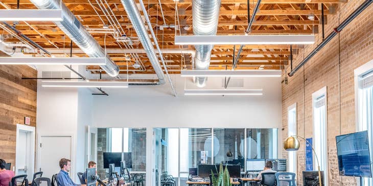 a team of Full Stack Engineers working on their respective workstations with the interior of the office being shown as well