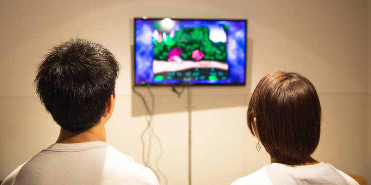 two Game Programmers testing a product prototype on the wall-mounted television