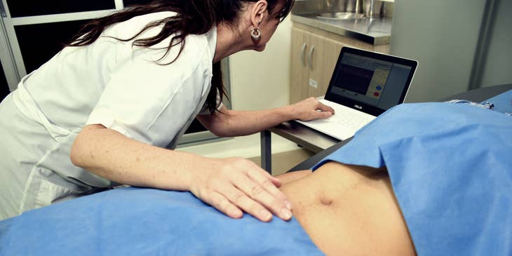 Gastroenterologist performing an abdominal check-up on the patient.