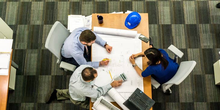 female Geotechnical Engineer presenting the blueprints to her clients for approval