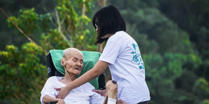 Home Health Aide positioning the patient to the wheelchair.