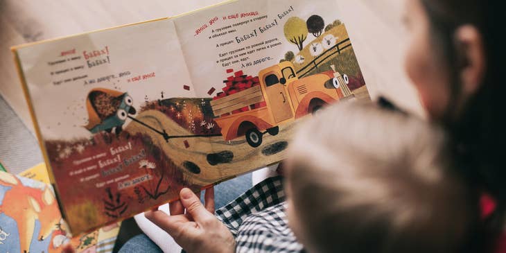 Infant Teacher reads a book about trucks to a toddler