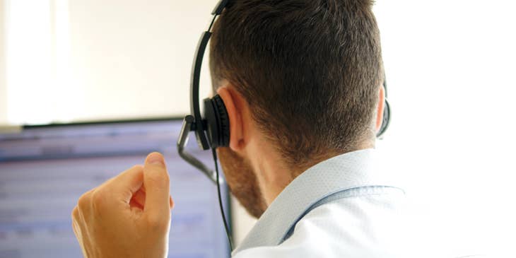 An Insurance Agent with a headset sitting in front of a computer.