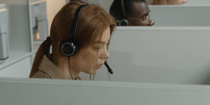 A group of Insurance Customer Service Representatives in a call center setting with headsets on answering calls.