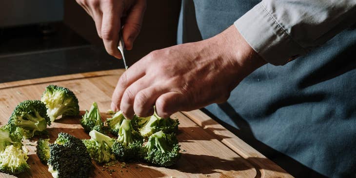 A kitchen assistant chopping vegetables.