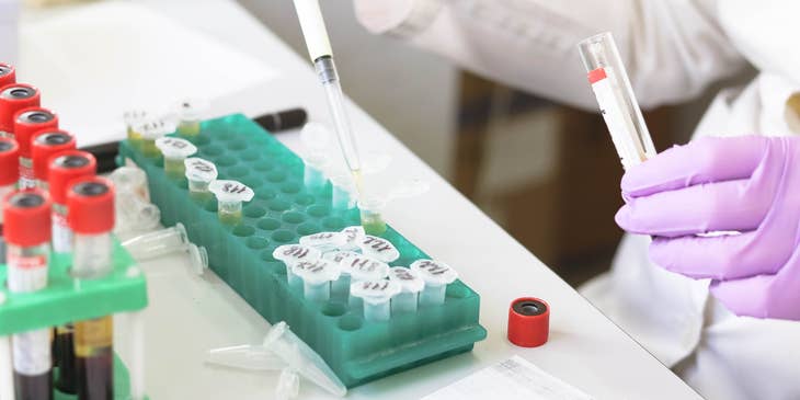 Lab technician holding a pipette and running tests