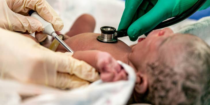 Labor and delivery nurse performing tests on newborns after birth.