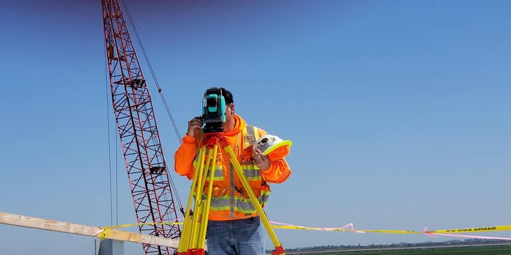 Land surveyor evaluates the construction site by using a special tool.