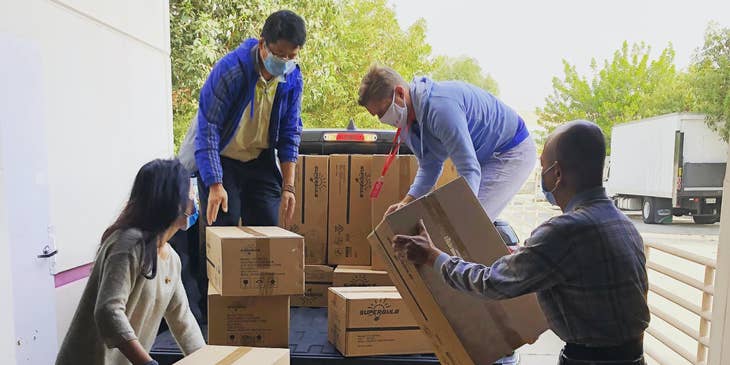 A logistics coordinator organizing and handing over packages for transportation with his team members.