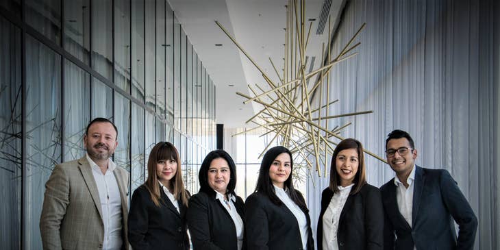 Photo of the managing director wearing a plaid suit with the rest of the members of the executive team to be disseminated at the company newsletter