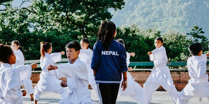 Martial arts instructor teaching a group of yound students