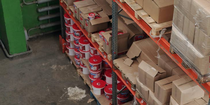 A materials manager in a warehouse assisting and showing the new workers around the work area.