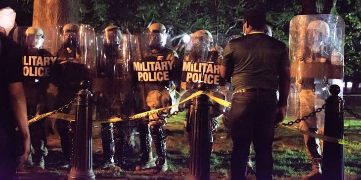 Military police officers lined up for duty outside a secured area during nighttime