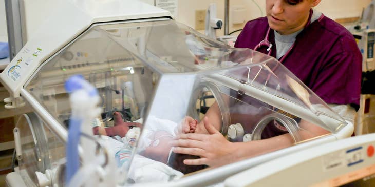 Neonatal nurse caring for the infant in NICU.