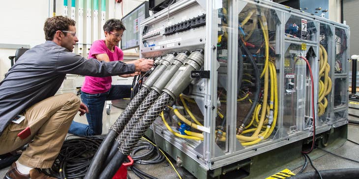 Network support technicians managing the cables of one of the company's servers