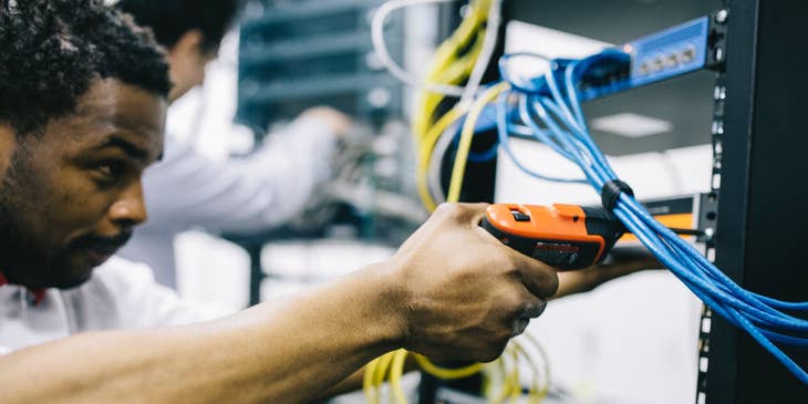 focused photo of a network technician installing a new set of servers for company use