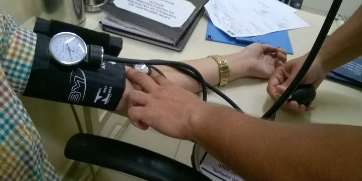 Nursing assistant taking patients' blood pressure.