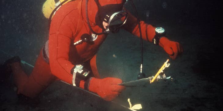 Oceanographer diving in the ocean to setup the equipment for underwater survey.