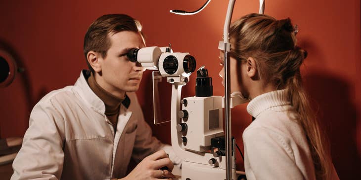 Ophthalmologist performing a vision testing on a young girl.