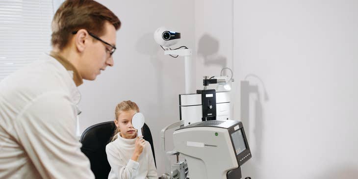 Optometric assistant taking visual acuity test.