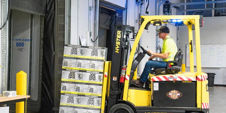 Order selector operating a forklift to transfer the order for shipping