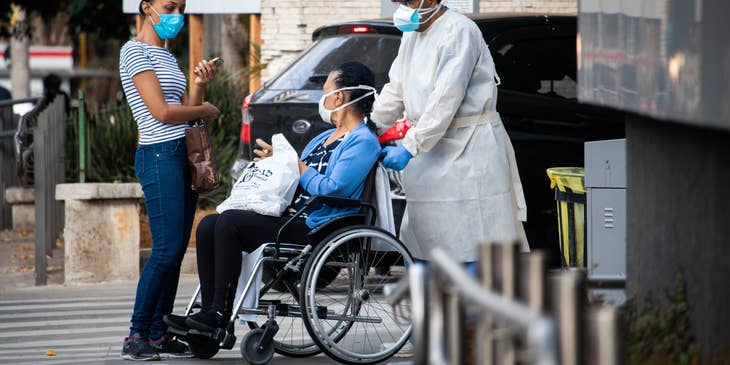 Orderly attendant pushing a wheelchair of a discharged patient.