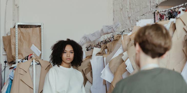 personal stylist working with a female client with clothes racks behind her