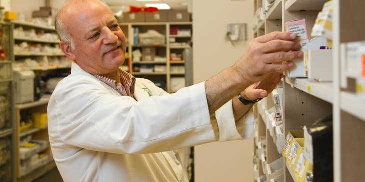 Pharmacist accurately checks the medicine on the shelf.