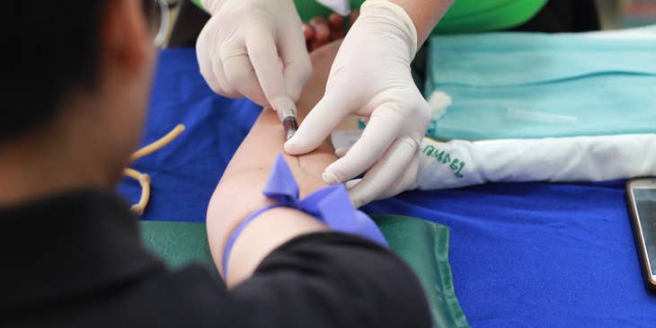 Phlebotomist extracts blood from the patient for diagnostic findings.