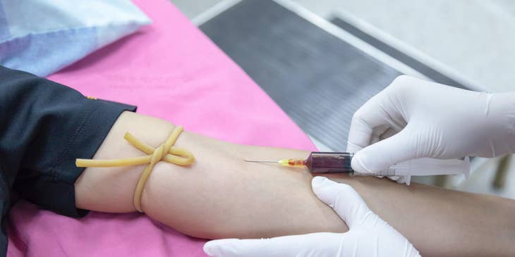 Phlebotomy technician extracts blood from the patient for blood donation.