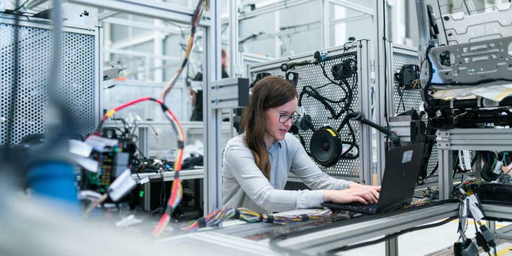 PLC programmer modifying the code of a machine program to be injected to the new production unit