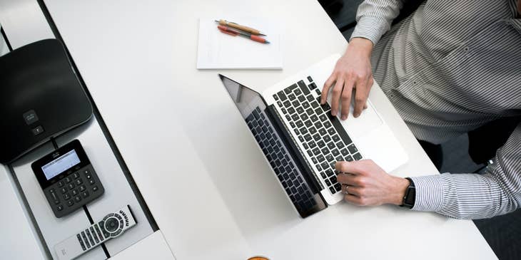 Proposal Writer typing on his laptop to finish the documents needed during the pitch