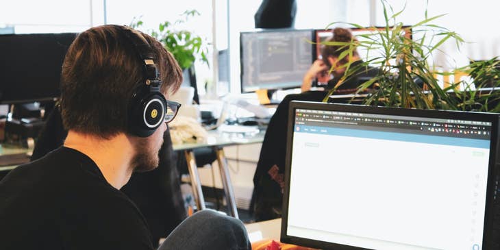QA Automation Engineer wearing a headset and working on test designs at his workstation