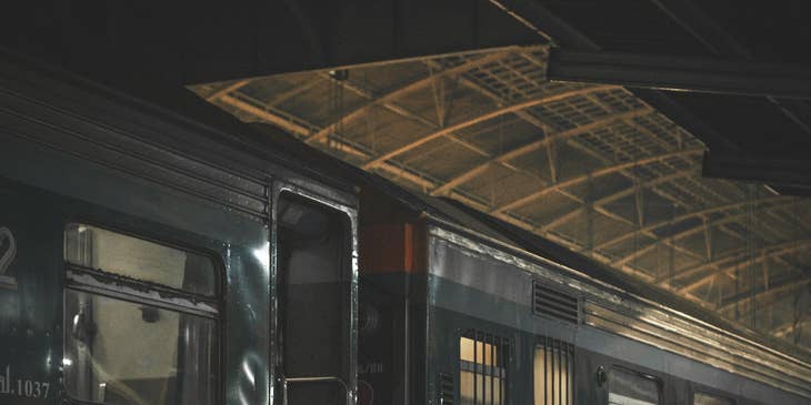 A railroad conductor standing outside a train getting ready and about to verify passengers' tickets.