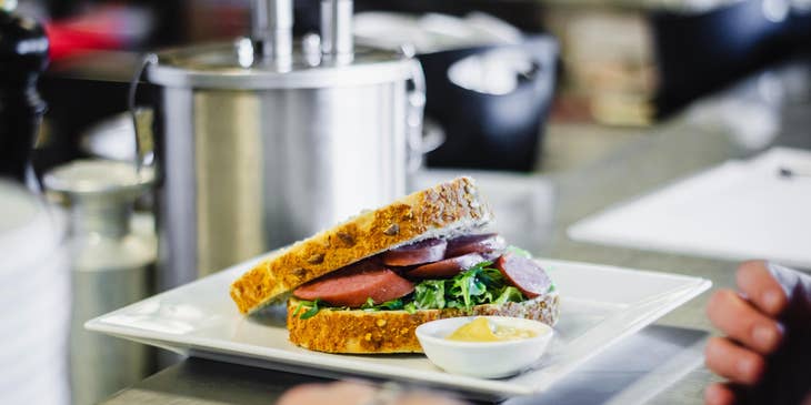 Sandwich Artist preparing sandwich in a deli.