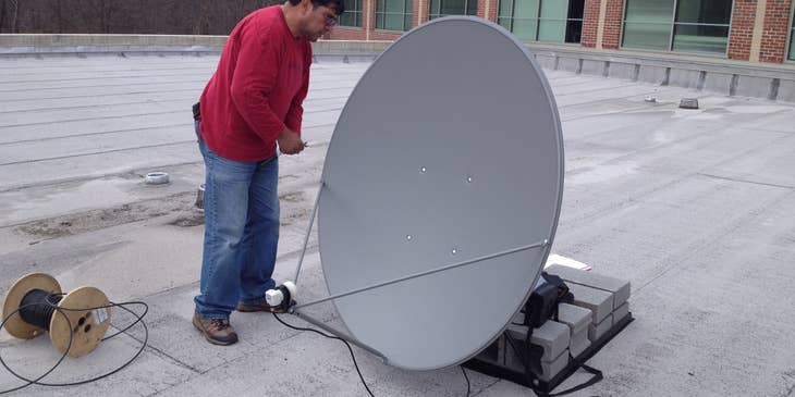 Satellite Technician repairing a satellite dish