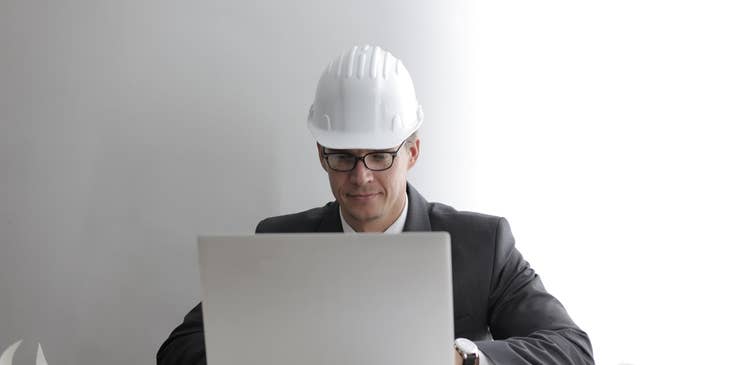 Senior estimator on his laptop preparing cost analysis for construction project.