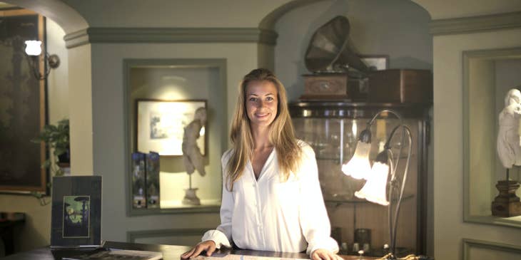 female service manager smiling and standing behind the counter