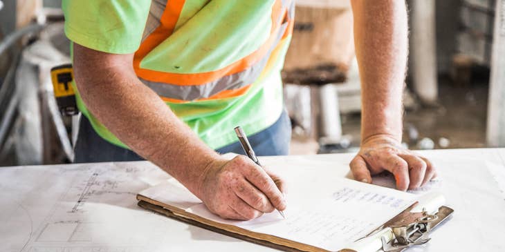 Site supervisor doing a checklist of construction site's progress.