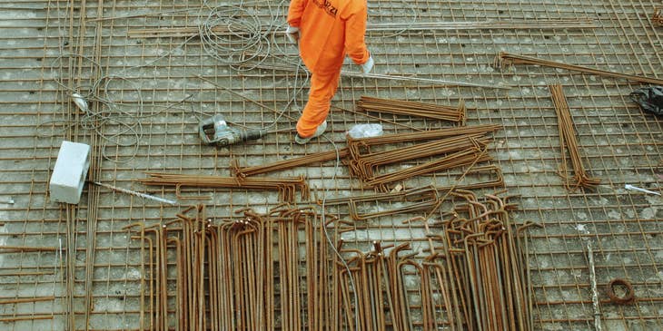 Steel fixers positioning steel bars on construction site.